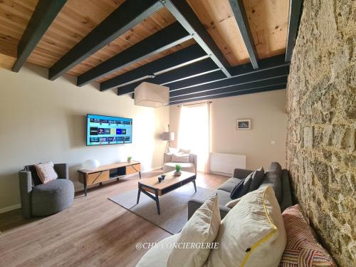 ein Wohnzimmer mit Sofa und Tisch in der Unterkunft Maison de campagne HDH - Charme et moderne - Proche du Puy duFou in LʼÉpaux