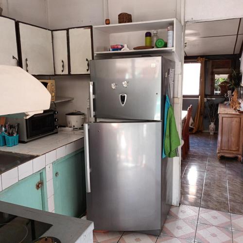 a kitchen with a stainless steel refrigerator at Feunteun Veur in Saint-Paul