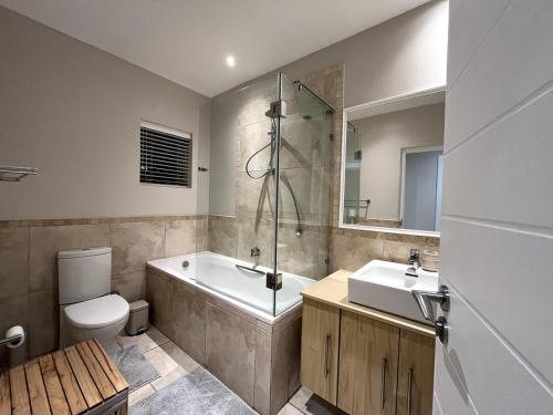 une salle de bain avec une baignoire, des toilettes et un lavabo dans l'établissement Thulana Tides, Plettenberg Bay, à Plettenberg Bay