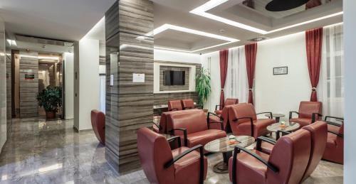 uma sala de espera com cadeiras, mesas e uma TV em Theater Hotel Belgrade em Belgrado