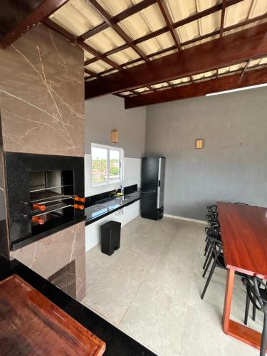 a large kitchen with a table and a refrigerator at Triplex Dunas - Flecheiras in Trairi