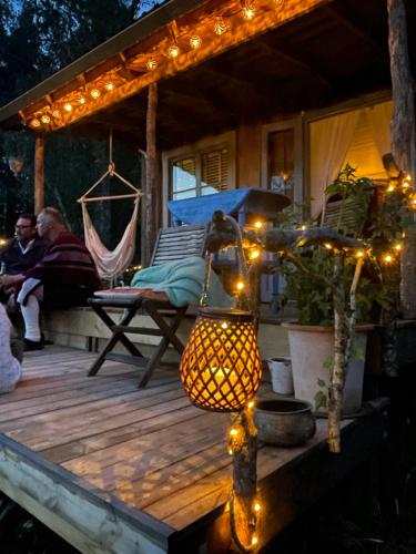 a porch with lights and a hammock on a deck at Vista Vibes Glamping -Chillbillystuga in Grillby
