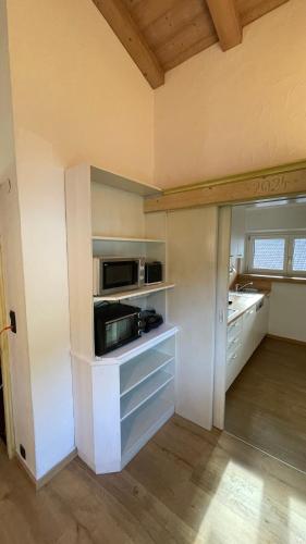a kitchen with white cabinets and a microwave at Beim Franz in Lermoos