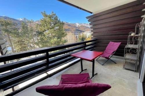 - un balcon avec une table rouge et deux chaises dans l'établissement Cosy T2 with sunny terrace in Saint-Chaffrey, à Saint-Chaffrey