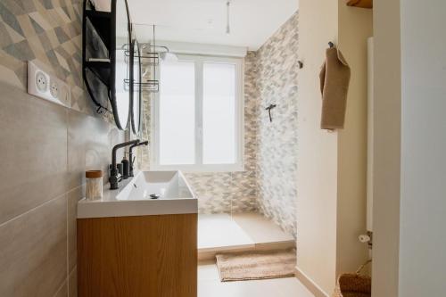 a bathroom with a sink and a window at Nuage De Lin - Charme naturel, proche gare in Saint-Nazaire
