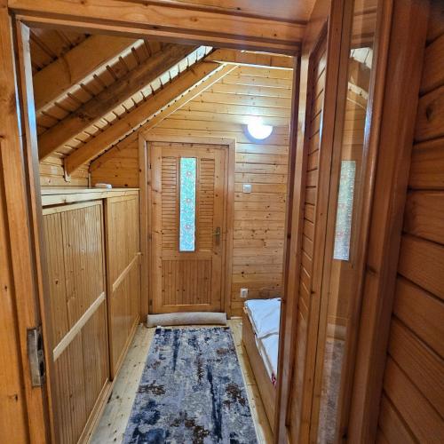 a hallway of a wooden cabin with a door at Magic Cottage From Paradise in Râu de Mori