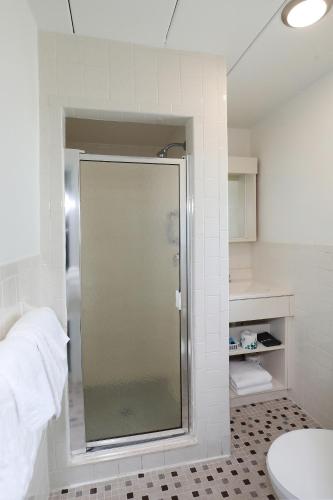 a glass shower in a bathroom with a toilet at Lark Motel in Stone Harbor