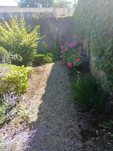 a garden with flowers and a stone wall at Studio cosy à Sedan avec jardin clôturé de 22 m² in Sedan