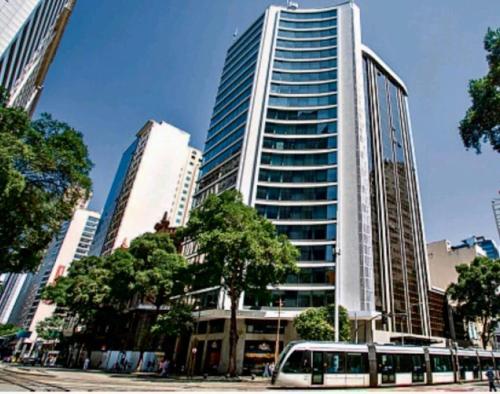 Un autobús está estacionado frente a un edificio alto. en Studio Luxury - piscina e ar condicionado, en Río de Janeiro