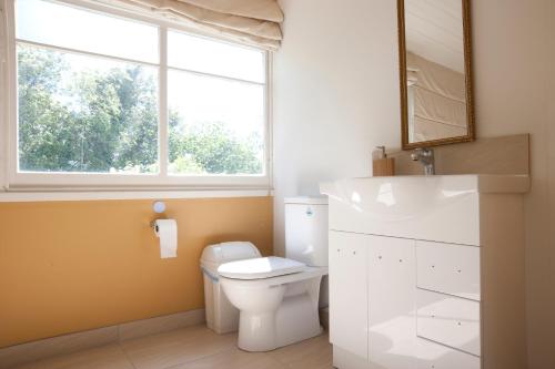 a bathroom with a white toilet and a window at Lowena Cafe and Accommodation in Hobart