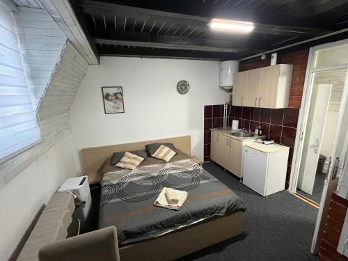 a small bedroom with a bed and a kitchen at Stan na dan Raška in Raška