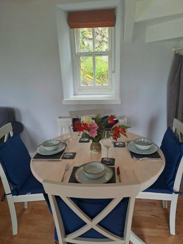 a table with plates and glasses and flowers on it at Hollybank, Kyleakin in Kyleakin
