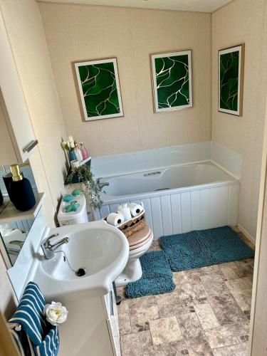 Un baño con lavabo, bañera e inodoro. en Celebration by the sea, en Redcar
