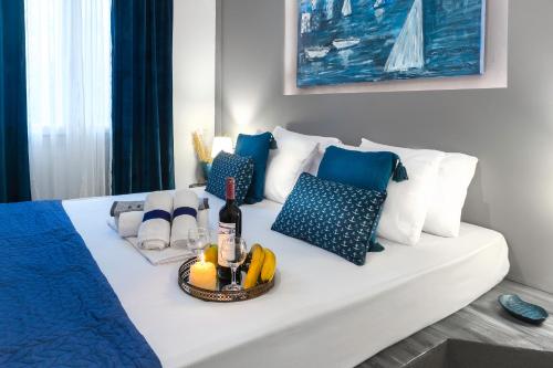 a white bed with a bottle of wine and pillows at MarGio Bay in Limenas