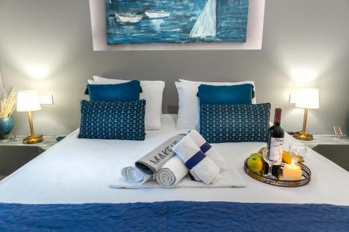 a bed with towels and a tray with a bottle of wine at MarGio Bay in Limenas