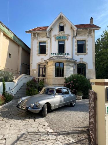 a silver car parked in front of a building at Hôtel Beausoleil in Montélimar