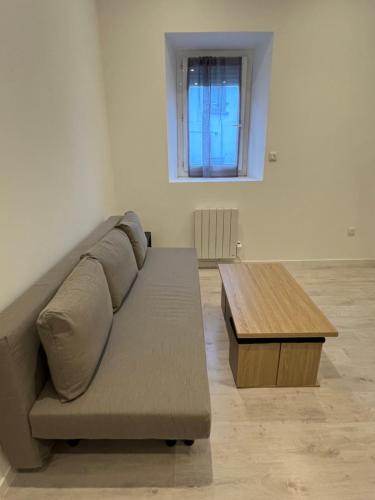 a living room with a couch and a wooden table at Résidence Coeur de Lourdes in Lourdes