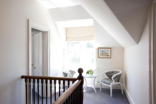 a staircase with two chairs and a table and a window at Lowena Cafe and Accommodation in Hobart