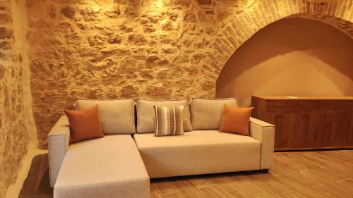 a couch in a room with a stone wall at Casa Stratigos in Corfu