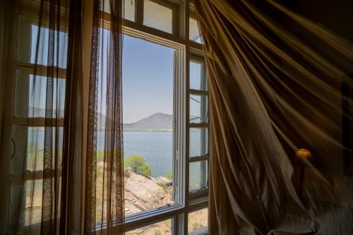 a window with a view of the ocean at Hotel Merwara Estate- A Luxury Heritage Resort in Ajmer