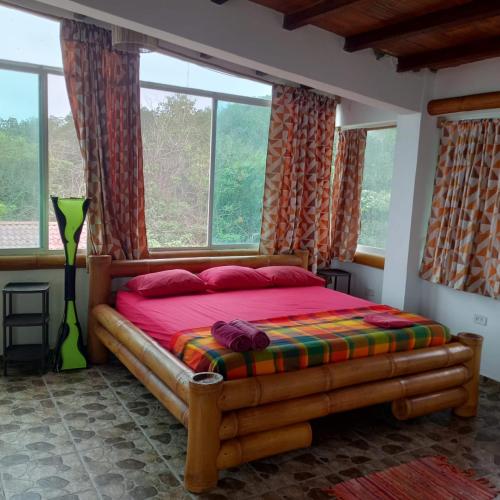 a bedroom with a wooden bed in a room with windows at hotel manglar in Mompiche