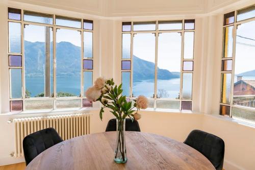 a vase of flowers on a table in a room with windows at Ghiffa villa rental in Ghiffa
