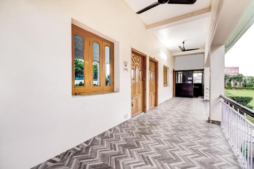 a corridor of a house with white walls and tile floors at Super Capital O Gulmohar Marriage Garden in Dhanbād