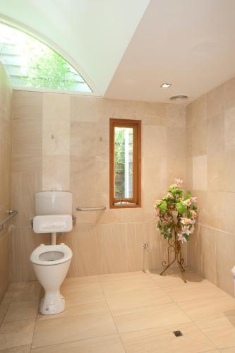 a bathroom with a toilet and a window at Lowena Cafe and Accommodation in Hobart