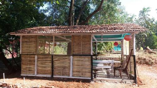 a wooden shed with a porch and a swing at Kamshet Lakeside Serene Artist Villa in Somavadi
