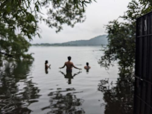 a group of people swimming in a lake at Kamshet Lakeside Serene Artist Villa in Somavadi