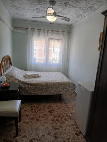 a small bedroom with a bed and a window at Cozy room in Denia
