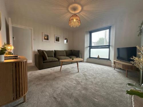 Una sala de estar con un sofá y un televisor. en Rosa's Retreat, en Falmouth
