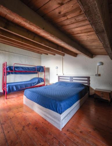 a bedroom with two beds and a wooden floor at Casetta Anna Natura Trekking e Pace nel Parco delle 5 Terre a 350 m slm lontana dal caos info dettagliate alla voce host in Riomaggiore