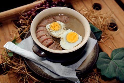 a bowl of soup with eggs and meat on a plate at Oberża Złota Gęś in Siewierz
