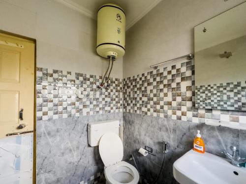 a bathroom with a white toilet and a sink at The Khayabaan - Your Fully Equipped Air-Conditioned Serviced Apartments in Srinagar in Srinagar