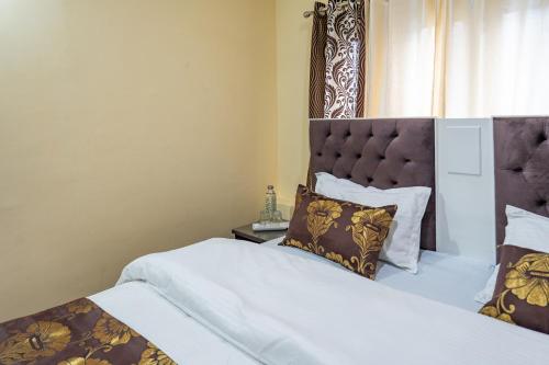 a bedroom with two beds and a headboard at The Khayabaan - Your Fully Equipped Air-Conditioned Serviced Apartments in Srinagar in Srinagar