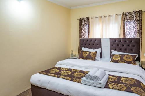 a bedroom with a large bed with a large headboard at The Khayabaan - Your Fully Equipped Air-Conditioned Serviced Apartments in Srinagar in Srinagar
