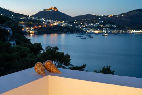 two donuts sitting on top of a railing with a view of the water at The Blue Nest in Nisís Léros