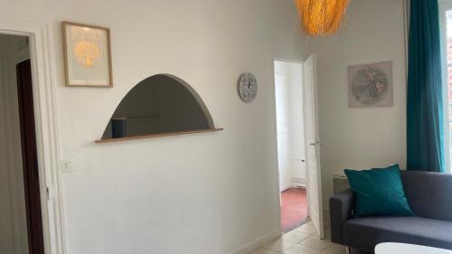 a living room with a couch and a clock on the wall at MEAUX Centre 1 au calme Vue sur cour intérieur in Meaux