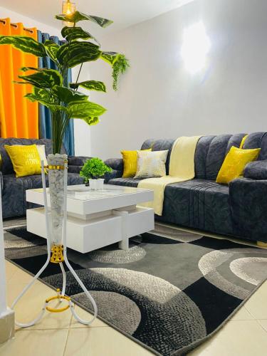 a living room with a blue couch and yellow pillows at Fames Elite Stays in Kitengela 