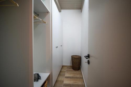 a small hallway with a white door and a basket at The Blue Nest in Nisís Léros