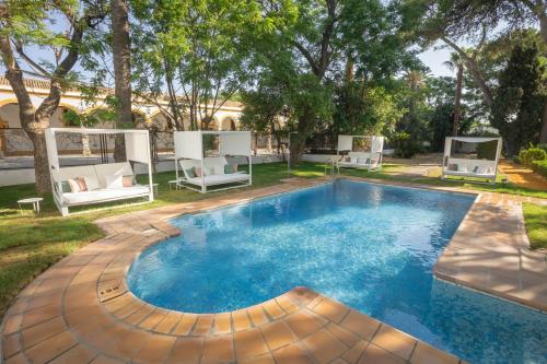 a swimming pool with two chairs and a house at Soho Boutique Duques de Medinaceli - Adults Recommended in El Puerto de Santa María