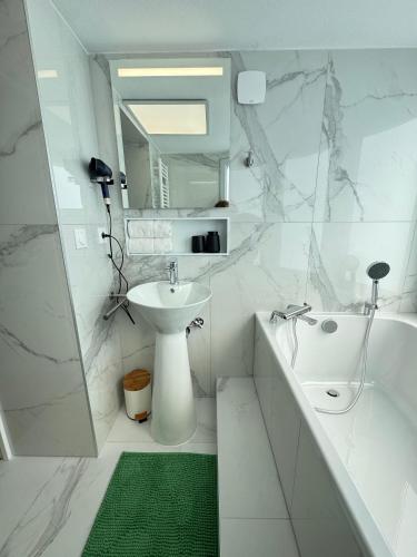 a white bathroom with a sink and a toilet and a tub at Hélios Plage in Berck-sur-Mer