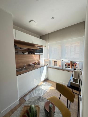 a kitchen with white cabinets and a table and chairs at Hélios Plage in Berck-sur-Mer