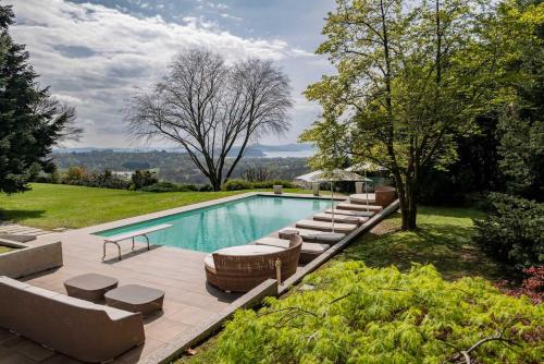 una piscina con sofás y sillas junto a en Italian Lakes villa with heated pool, en Besozzo