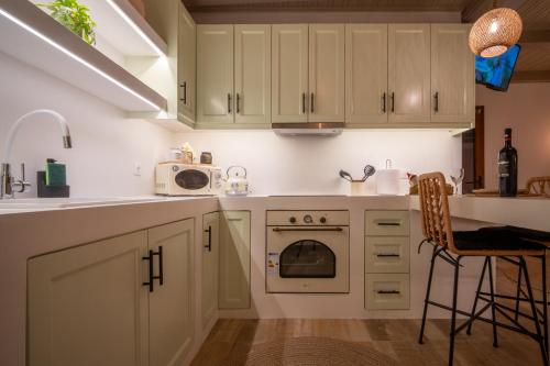 a kitchen with white cabinets and a stove top oven at The Blue Nest in Nisís Léros