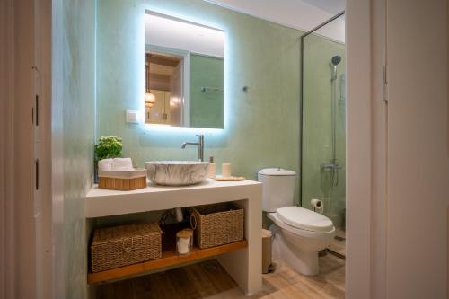 a bathroom with a sink and a toilet and a mirror at The Blue Nest in Nisís Léros