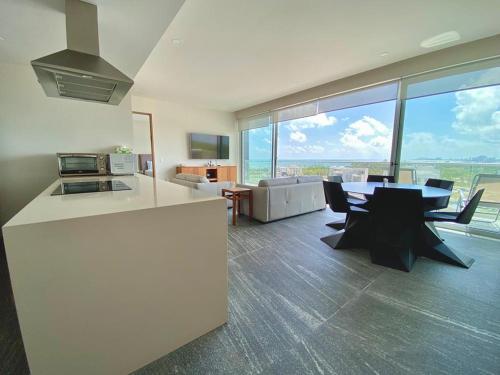 a kitchen and living room with a table and chairs at Rooftop pool- family apartment- ocean view -close in Cancún