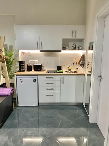a small kitchen with white cabinets and a sink at ATHENIAN Vibes in Athens