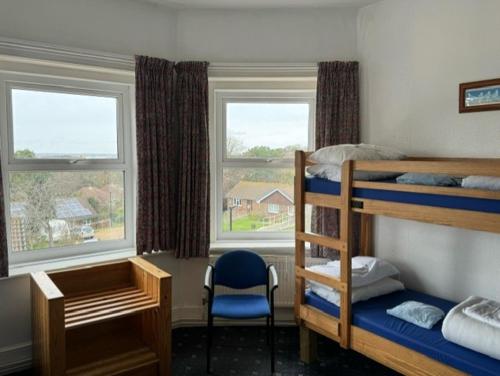 a bedroom with bunk beds and a desk and a chair at YHA Isle of Wight Totland - Partner in Totland